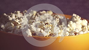 Fresh hot popcorn drops in a bowl.Fresh crispy popcorn drops in a bucket.