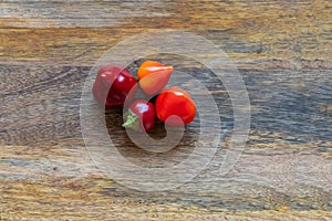 Fresh hot red peppers on wooden background top view