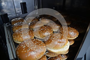 Fresh hot sweet buns with sesame seeds from the oven, homemade bakery.