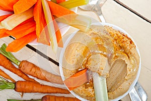 Fresh hummus dip with raw carrot and celery