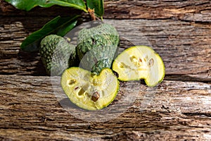 Fresh hybrid fruit of atemoia Annona cherimolia Mill x Annona squamosa L. in matedes on wooden background photo