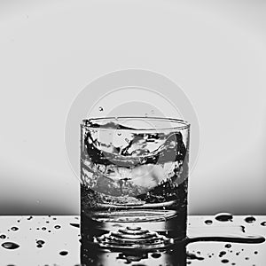 Fresh ice cube falling to glass of water splash isolated