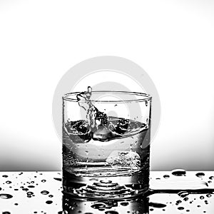 Fresh ice cube falling to glass of water splash isolated