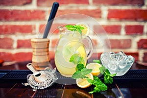 Fresh, iced mint lemonade in a jug with sliced lem