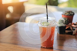 Fresh iced tea with lime in plastic cup