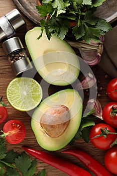 Fresh ingredients for guacamole on wooden table, flat lay