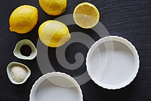 Fresh ingredients for lemon pie foodie baking on slate countertop