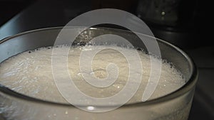 Fresh intoxicating beer is poured into a glass. Foam bubbles, a natural product.