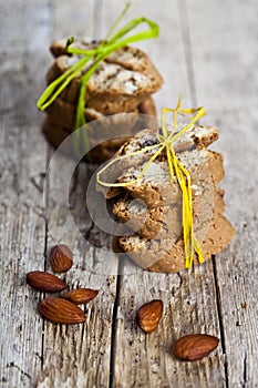 Fresh Italian cookies cantuccini stackes and almond nuts on ructic wooden table background