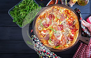 Fresh Italian pizza with chicken fillet, mushrooms, ham, salami, tomatoes