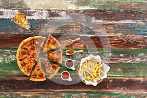 Fresh Italian pizza and french fries served on rustic wood table, with ketch up and drink photo