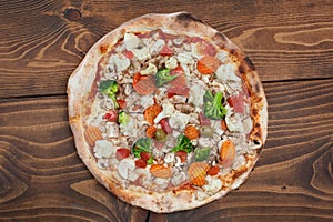 Fresh italian vegetariana pizza on wooden background, top view photo