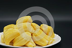 Fresh jackfruit slices on a white plate. sweet yellow jackfruit ripe. vegetarian, vegan, raw food. Exotic tropical fruit