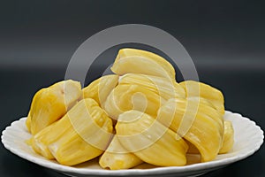 Fresh jackfruit slices on a white plate. sweet yellow jackfruit ripe. vegetarian, vegan, raw food. Exotic tropical fruit - isolate