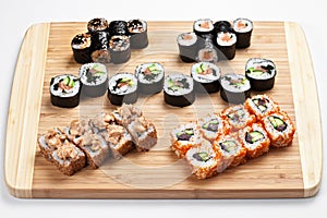 Fresh japanese sushi rolls set on a wooden board