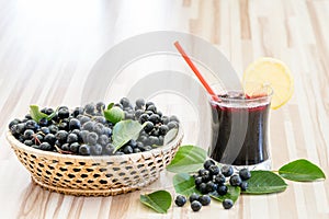 Fresh juice of chokeberry or Aronia melanocarpa in glass and berry in pot