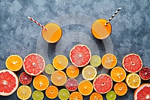 Fresh juice or smoothie vitamin detox drink in citrus fruits background flat lay on concrete table