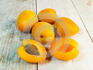 Fresh juicy apricots on a light wooden tabletop