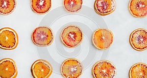 Fresh juicy blood orange slices over light marble table background