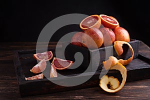 Fresh juicy blood oranges in a box on a dark wooden background, rustic style, healthy food