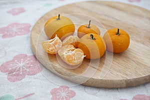Fresh juicy clementine mandarins on wooden board
