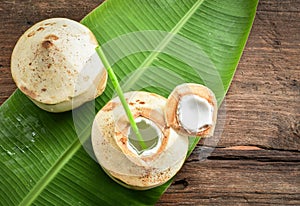 Fresh and juicy coconut fruits on banana leaf background.