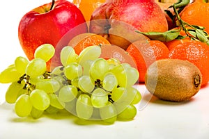 Fresh juicy fruit - bunches of grapes, mandarin, apple.