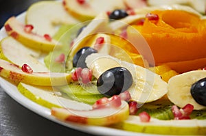 Fresh juicy fruit salad on a plate.