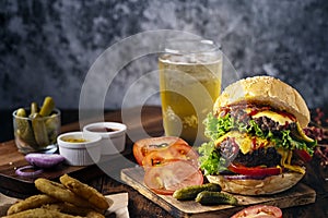 Fresh and juicy hamburger. Cheese burger with beef or bacon, patty tomato, onion ring and sparkling water or beer