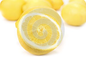 Fresh juicy lemons with halves on the white background.