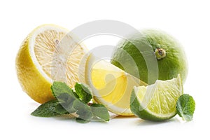 Fresh and juicy lime and lemon cut into pieces, with green leaves and mint