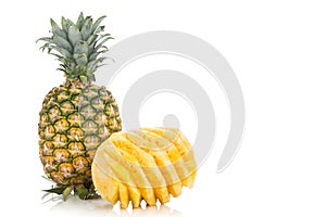 Fresh juicy nutritious cut pineapple with whole fruit as backgro