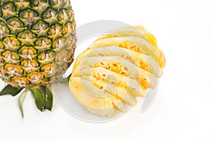 Fresh juicy nutritious cut pineapple with whole fruit as backgro