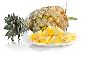 Fresh juicy nutritious cut pineapple with whole fruit as backgro