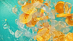 Fresh juicy orange and juice, ice cube and water drops splash pours in super slow motion 1000 fps. Citrus orange slices