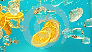 Fresh juicy orange and juice, ice cube and water drops splash pours in super slow motion 1000 fps. Citrus orange slices