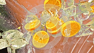 Fresh juicy orange and juice, ice cube and water drops splash pours in super slow motion 1000fps.Citrus orange slices