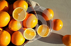 Fresh juicy oranges in wicker basket on table