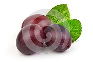 Fresh juicy ripe plums with leaves isolated on white background