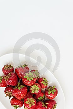 Fresh juicy strawberries on white plate, served with cutlery, is