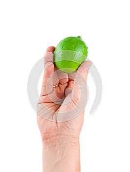 Fresh juicy tasty green lime in a human hand isolated on a white