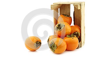 Fresh kaki fruit in a wooden crate