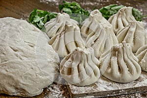 Fresh khinkali made from dough with meat inside, a national Georgian dish. Fresh dough, flour and herbs.