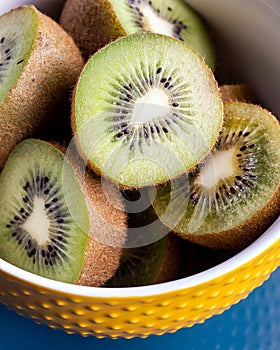 Fresh kiwi slices in a yellow ceramic bowl.