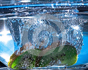 Fresh kiwis immersed in a transparent glass bowl filled with water