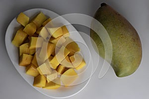 Fresh large totapuri mangoes sliced to small pieces, juicy and vibrant in color photo