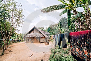 Fresh laundry drying in front of the traditional Laotian bamboo hut in a village near Nong Khiaw, Laos