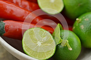 Fresh lemon cut half with chili in bowl on wooden table