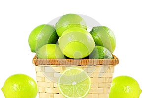Fresh lemon lime citrus fruit in bamboo basket in white background