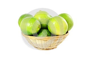 Fresh lemon lime citrus fruit in bamboo basket in white background